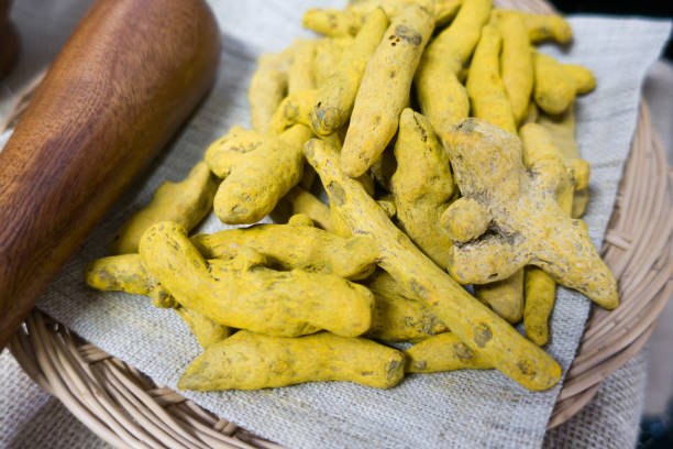 istock Yellow turmeric powder and dry roots on white background. 1328797261