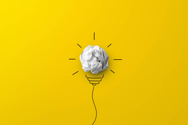 istock Creative thinking ideas and innovation concept. Paper scrap ball with light bulb symbol on yellow background 1328798777