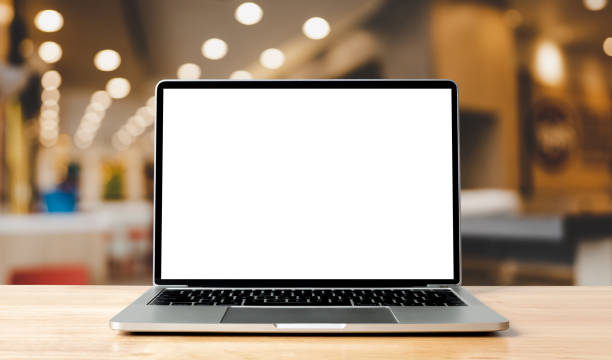 istock Laptop blank screen on wood table with blurred coffee shop cafe interior background and lighting bokeh, mockup, template for your text, Clipping paths included for background and device screen 1328798803