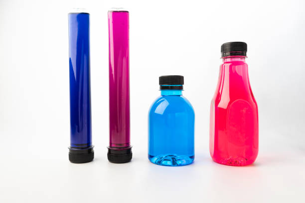 istock Plastic bottles and test tubes filled with colorful liquids on white background. Plastic containers filled with Blue, Navy blue, Pink and Purple food coloring 1328800844