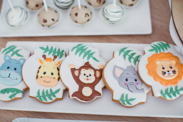Jungle safari animal birthday sweets. Cookies, macarons, cupcakes with sugar animal decorations