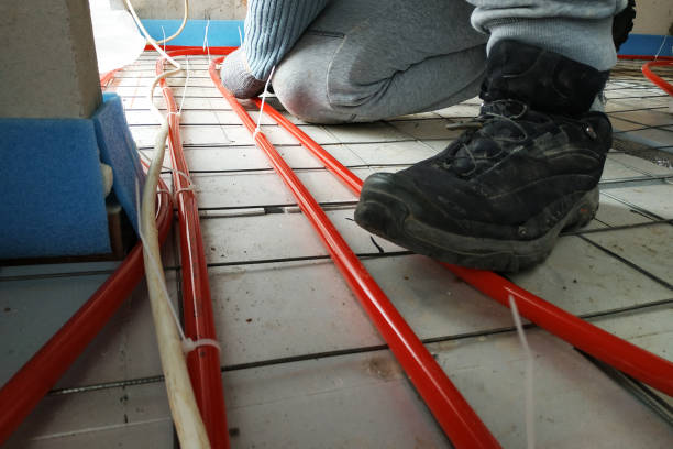 installation de tuyauterie du système de chauffage, le maître fixe les tuyaux à la mousse. - pipefitter photos et images de collection