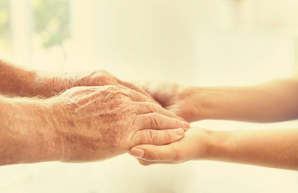 aiutare le mani su sfondo sfocato, primo piano. concetto di assistenza agli anziani - consoling close up senior adult grandparent foto e immagini stock