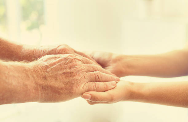istock Helping hands on blurred background, closeup. Elderly care concept 1328810694