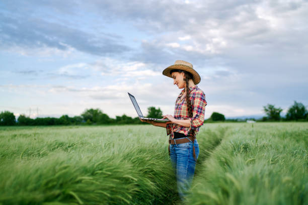 istock Female farm agronomist checking an agricultural field using laptop 1328811163