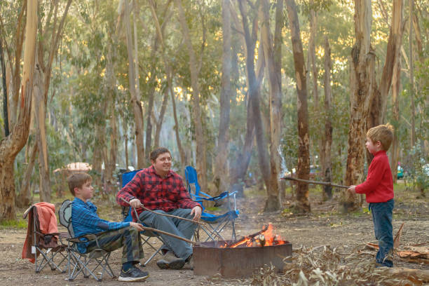 Kids with father burning fire at Kuitpo forest camping ground school holidays