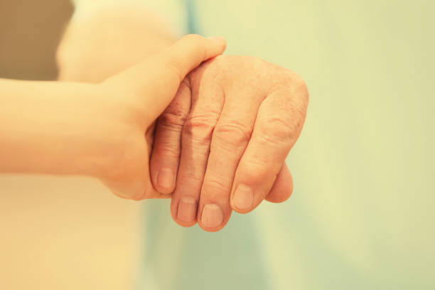 istock Helping hands on blurred background, closeup. Elderly care concept 1328811386