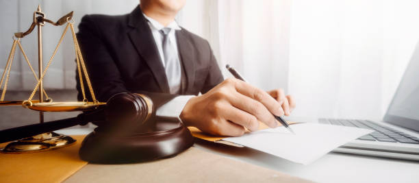 Business and lawyers discussing contract papers with brass scale on desk in office. Law, legal services, advice, justice and law concept picture with film grain effect Business and lawyers discussing contract papers with brass scale on desk in office. Law, legal services, advice, justice and law concept picture with film grain effect lawyer stock pictures, royalty-free photos & images