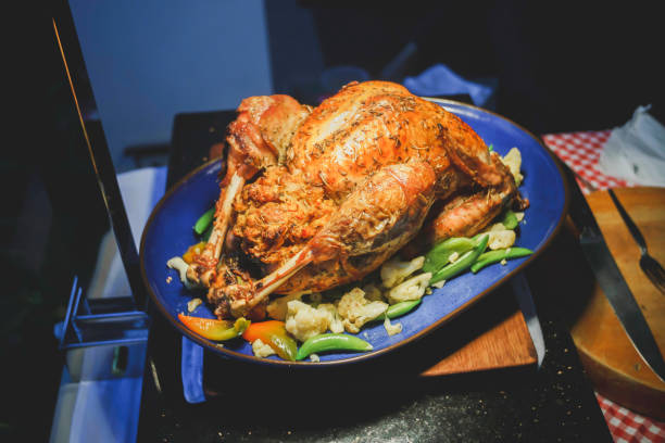 istock Whole roasted chicken with vegetables and fried potatoes on pan, on color wooden background 1328811451