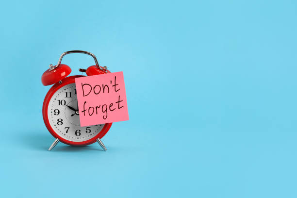 istock Alarm clock and reminder note with phrase Don't forget on light blue background, space for text 1328812285