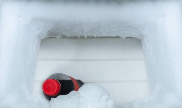 istock A bottle of cola soft drinks with ice cubes on freezing compartment of refrigerator, copy space for text. 1328812848