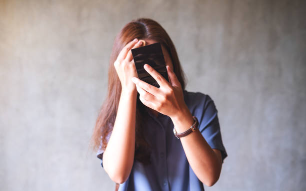 istock A young asian woman looking in a mirror while putting on makeup 1328814947