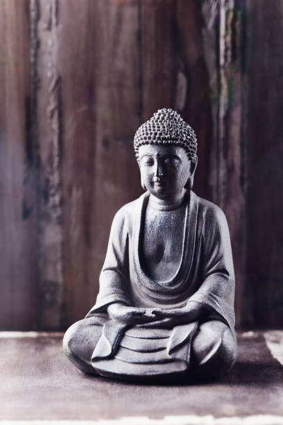 istock Meditating Buddha Statue on wooden background. Copy space. 1328814955