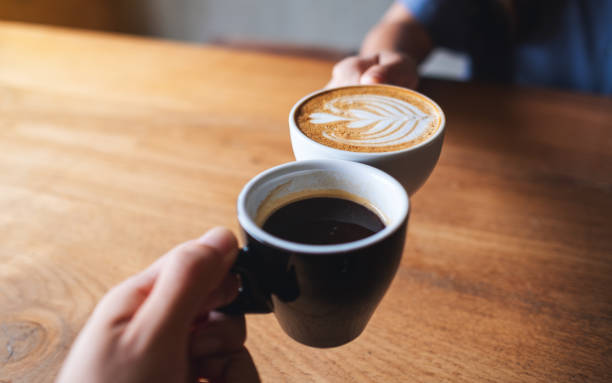 istock a man and a woman clinking white coffee mugs in cafe 1328814964