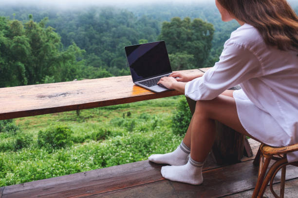 istock a woman using and working on laptop computer while sitting on balcony with a beautiful nature view on foggy day 1328814974
