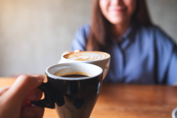 istock a woman and a man clinking coffee mugs together in cafe 1328814975