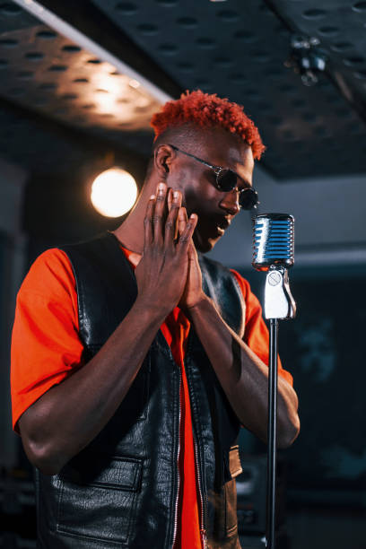istock Having vocal practice. Young african american performer rehearsing in a recording studio 1328815835