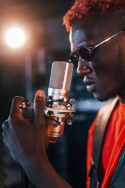 istock Having vocal practice. Young african american performer rehearsing in a recording studio 1328815845