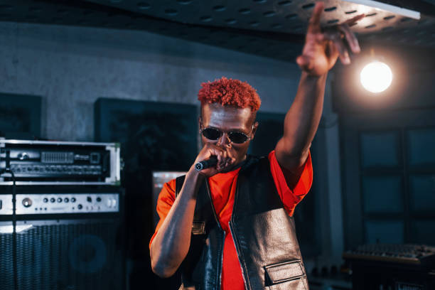 istock Having vocal practice. Young african american performer rehearsing in a recording studio 1328815876