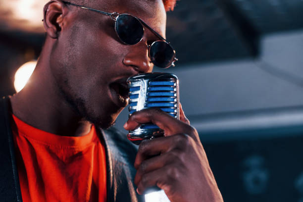 istock Having vocal practice. Young african american performer rehearsing in a recording studio 1328815907