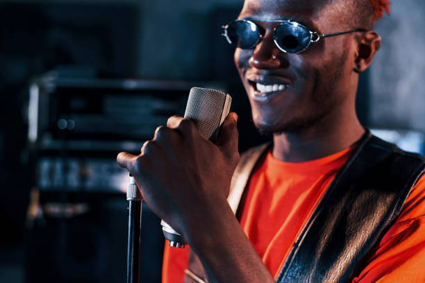 istock Having vocal practice. Young african american performer rehearsing in a recording studio 1328815976