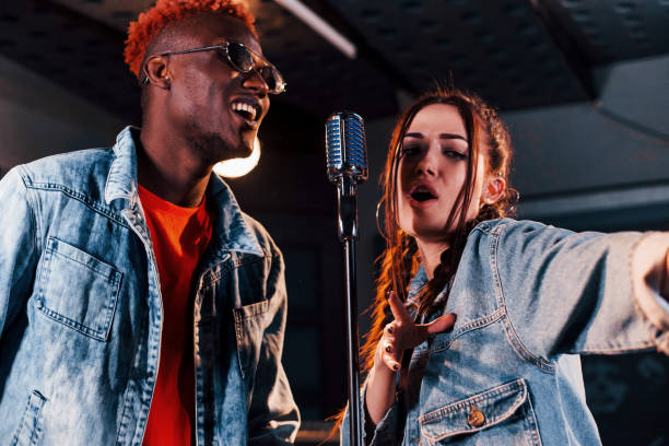 istock Two multi ethnic friends have a vocal practice in the studio together 1328815987