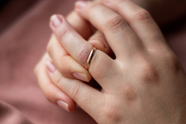 istock small wedding ring on a woman's hand. trying to take off 1328816013