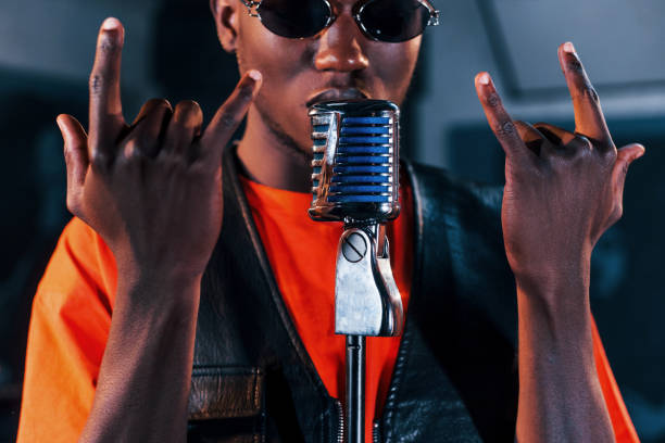 istock Having vocal practice. Young african american performer rehearsing in a recording studio 1328816019