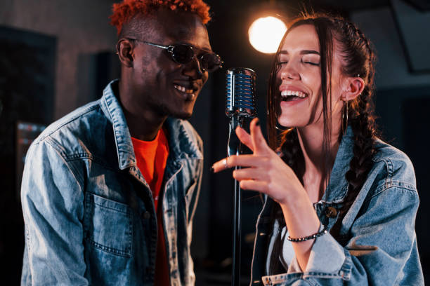 istock Two multi ethnic friends have a vocal practice in the studio together 1328816043