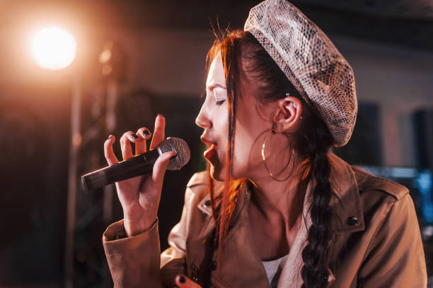 istock Young beautiful female singer rehearsing in a recording studio 1328816059