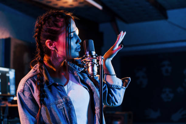 istock Young beautiful female performer sings and rehearsing in a recording studio 1328819082