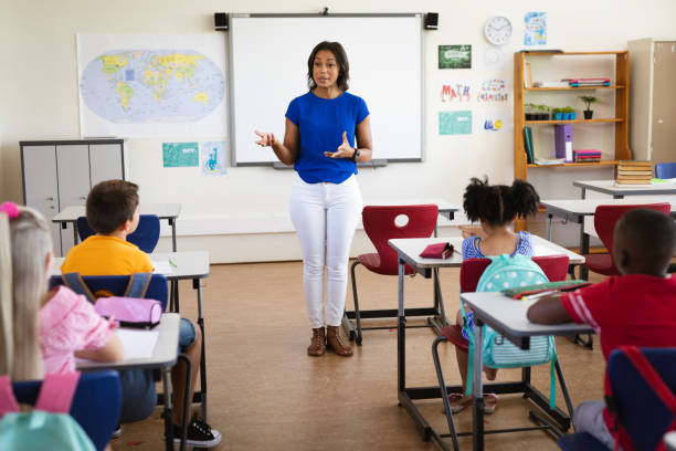 istock African american female teacher teaching students in the class at elementary school 1328820701