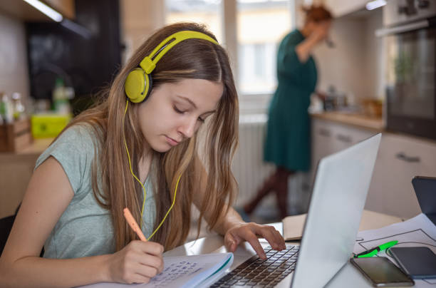 istock Teenage girl using laptop for online learning and taking notes, remote learning trend 1328820976