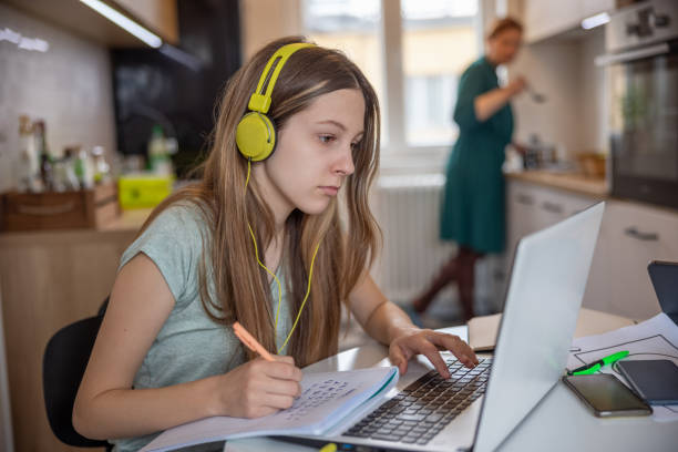 istock Teenage girl using laptop for online classes and taking notes, remote learning trend 1328820984