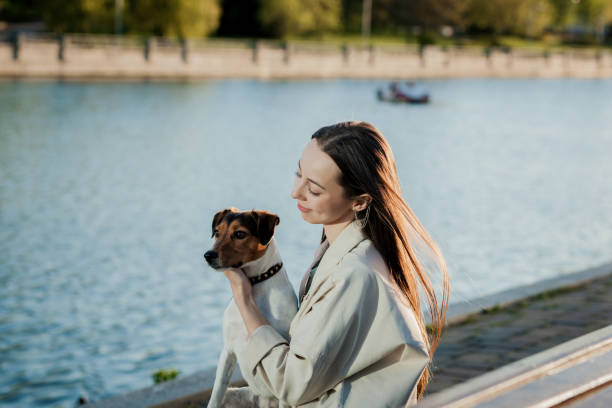 istock beautiful woman sitting on beach hugging dog 1328821211