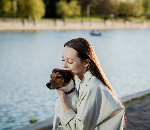 istock woman in hat sitting and hugging her dog 1328821223