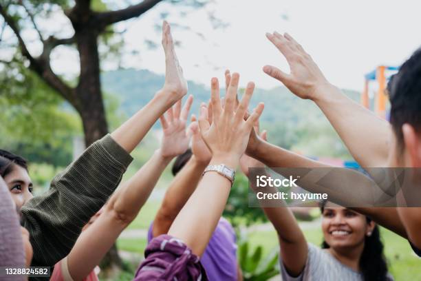 Multi Ethnic Asian People Giving Each Other A High Five Stock Photo - Download Image Now