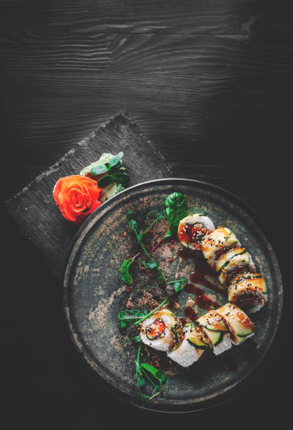 istock sushi roll in plate on black wooden table background 1328827797