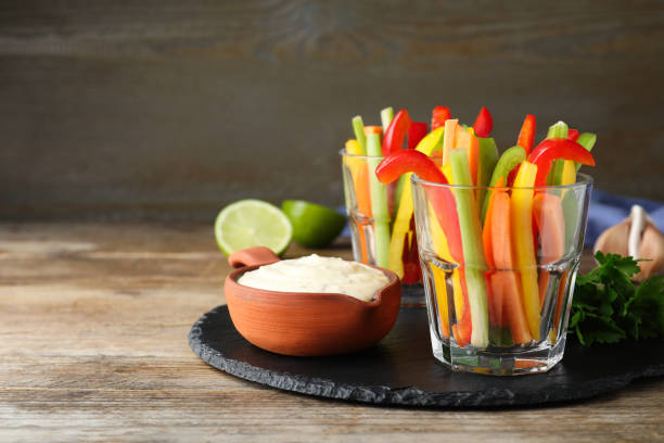 istock Fresh raw vegetable sticks and sauce on wooden table, space for text 1328831037