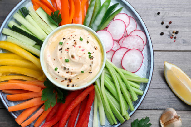 istock Fresh raw vegetable sticks and sauce on grey wooden table, flat lay 1328831790