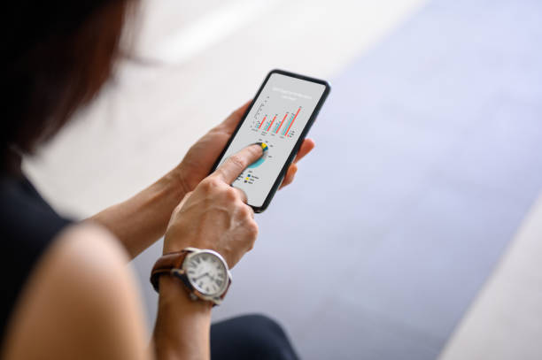 istock A businesswoman using a smartphone with graphs and diagrams for marketing development 1328833130