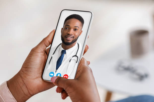istock Black woman having video chat with handsome doc, using phone 1328833561