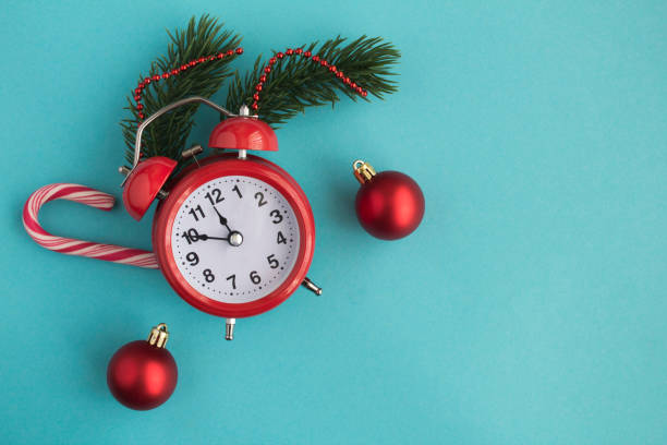 istock Red alarm clock and Christmas composition on the blue background. Top view. 1328835086