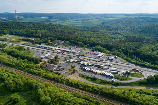 German highway, rest area and highspeed train railroad track - aerial view