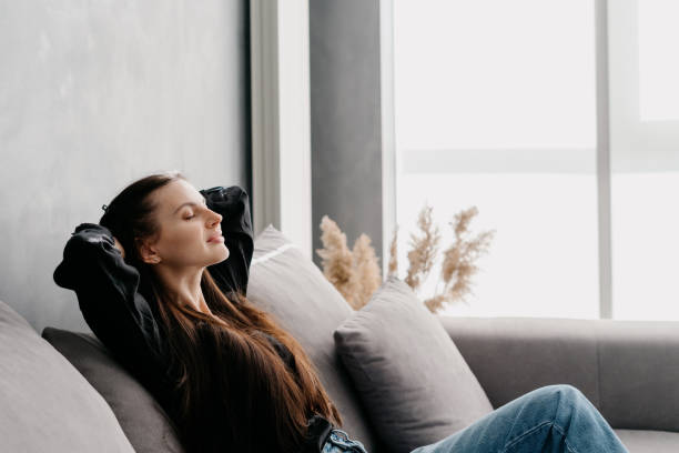 istock Relaxed woman resting and stretching on comfortable sofa 1328836653