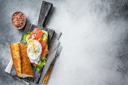 Sandwich with Poached egg, smoked salmon and avocado on toast.  White background. Top view. Copy space.