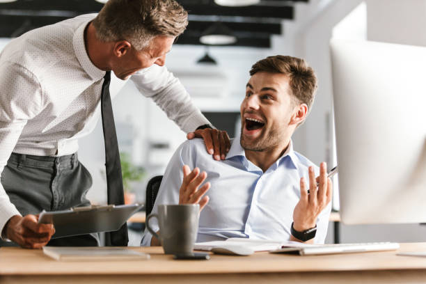 istock Happy emotional men colleagues in office working with computer. 1328838071