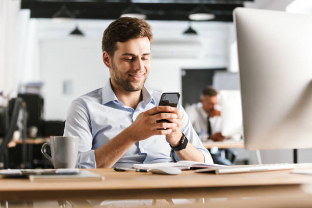 istock Smiling business man writing message on smartphone 1328838530