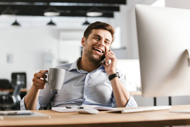 istock Happy business man talking by smartphone and drinking coffee 1328839843