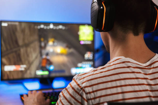 istock Back view of gamer playing video games on computer 1328841307